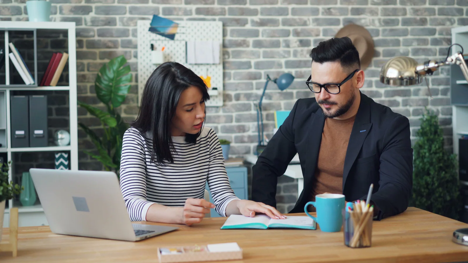 Two people discussing notes at an office table