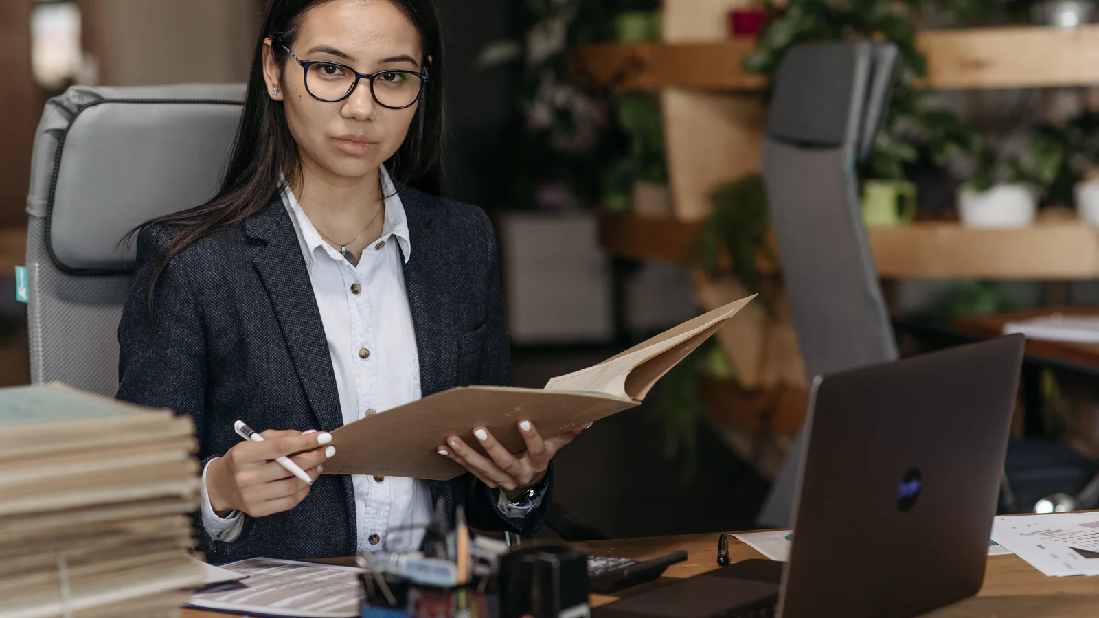 Person reviewing a folder of documents at an office desk