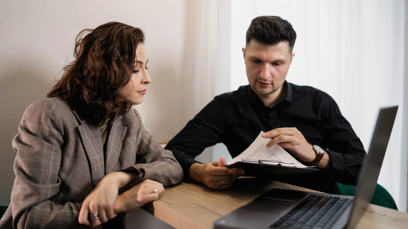 Two adults reviewing a document together at an office table
