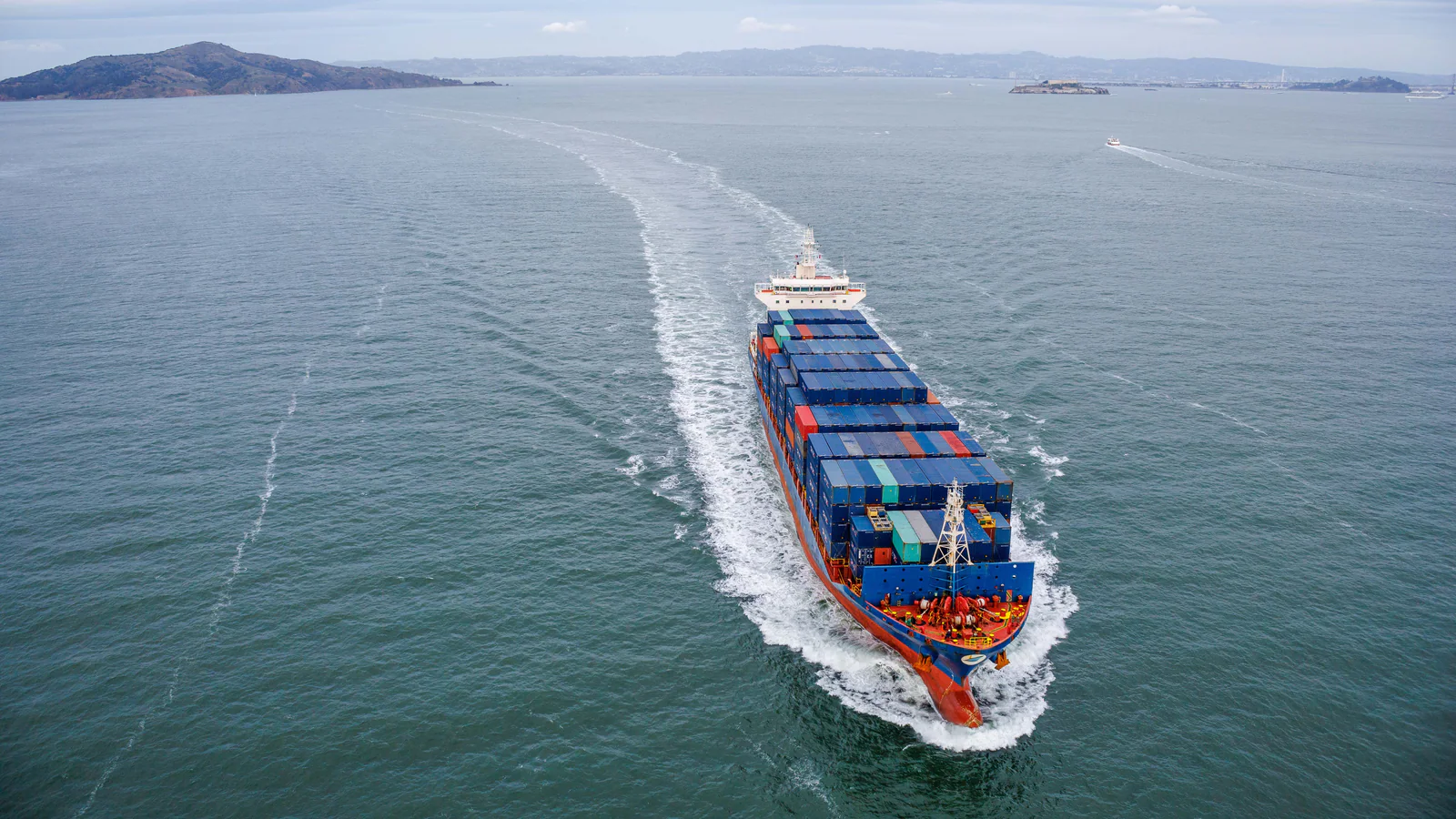 Container ship travelling through calm coastal waters