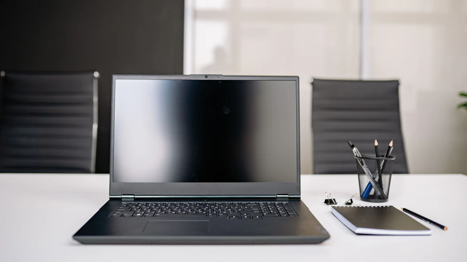 Laptop and notebook on a quiet conference-room table