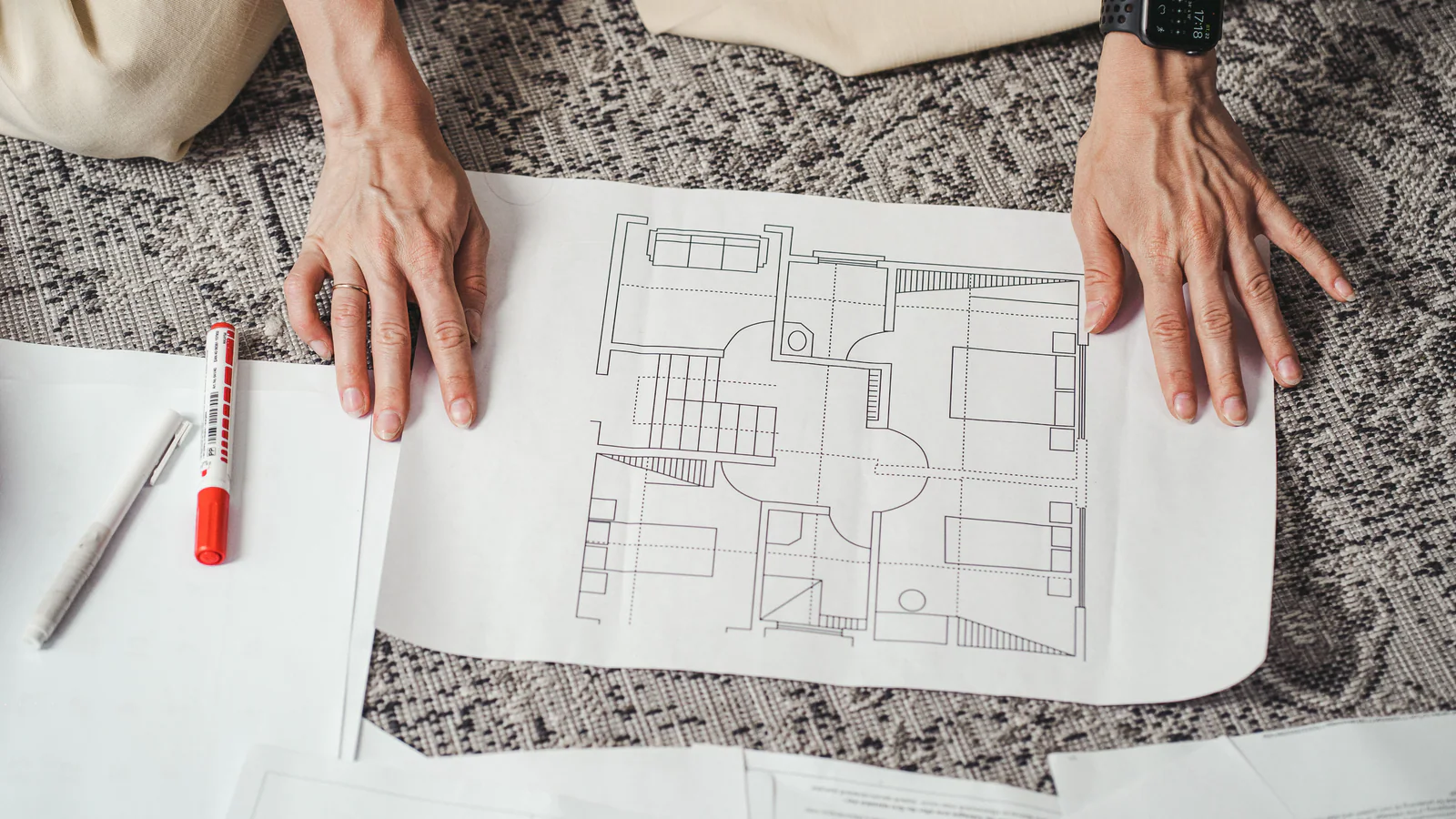 Hands reviewing an architectural floor plan