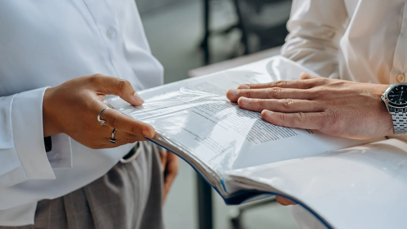 Two people reviewing documents together in a professional setting