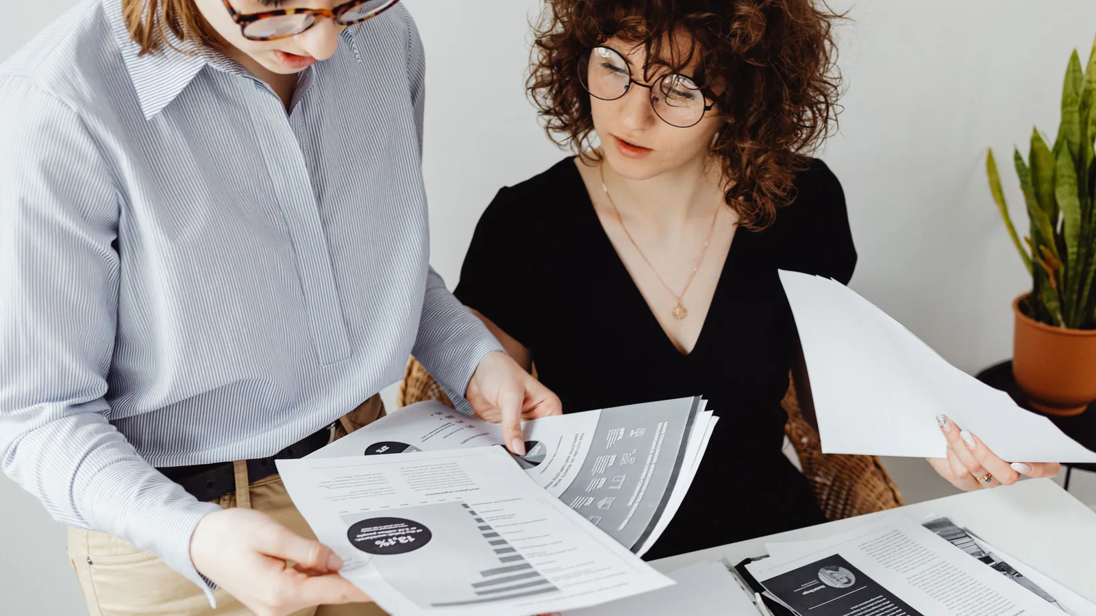 Two professionals reviewing business reports at a desk