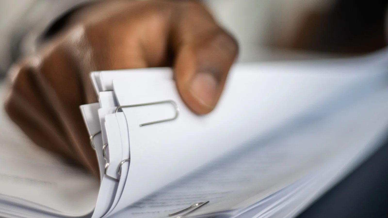 Hand sorting a clipped stack of documents